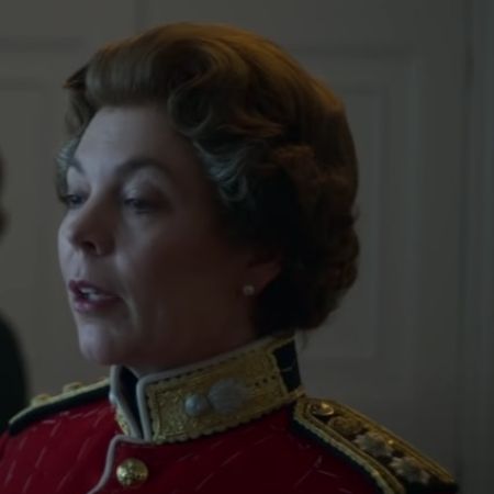 Olivia Colman is wearing a red royal dress in the picture.